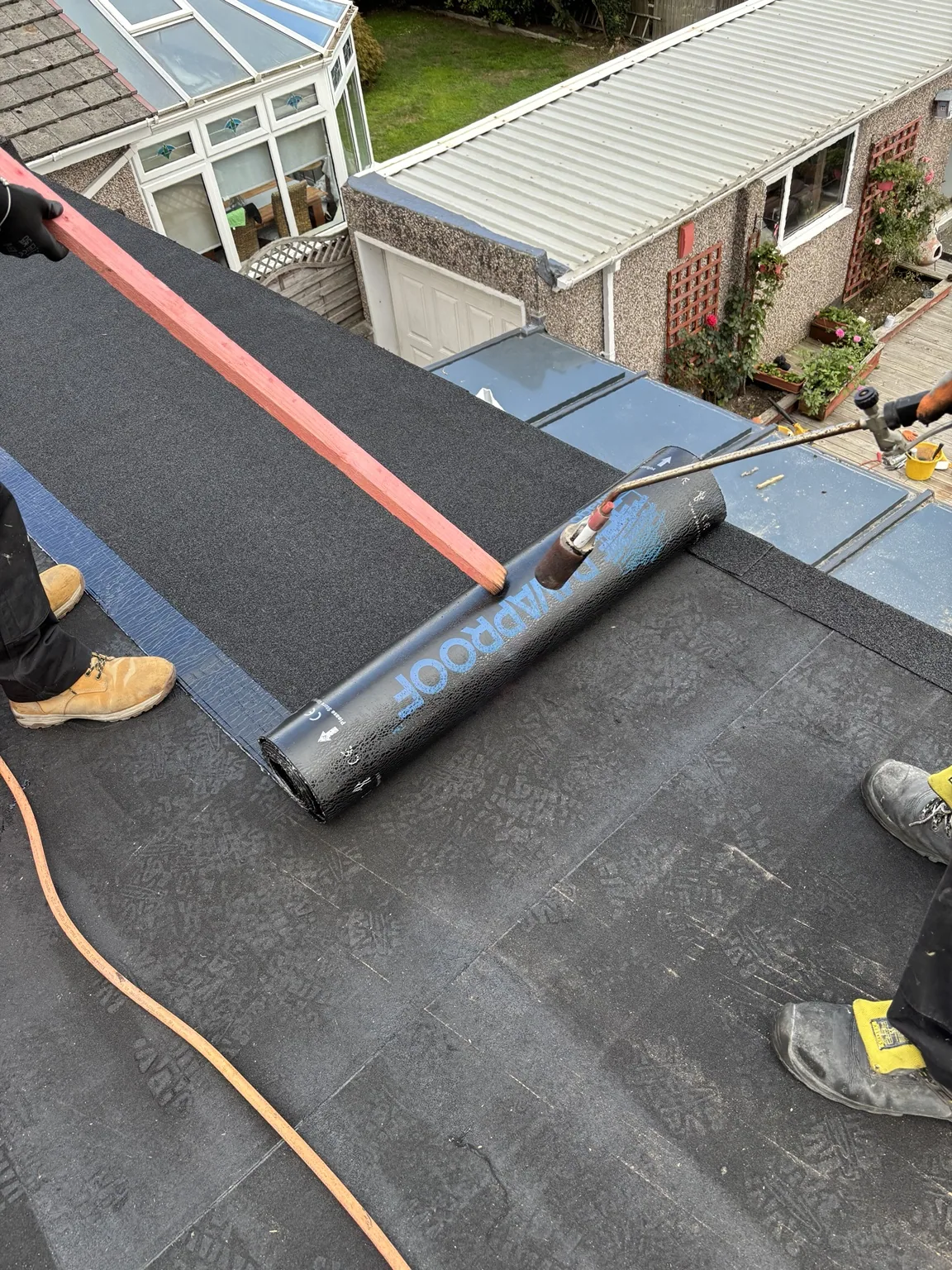 Torch-on bituminous felt being applied on a roofing project